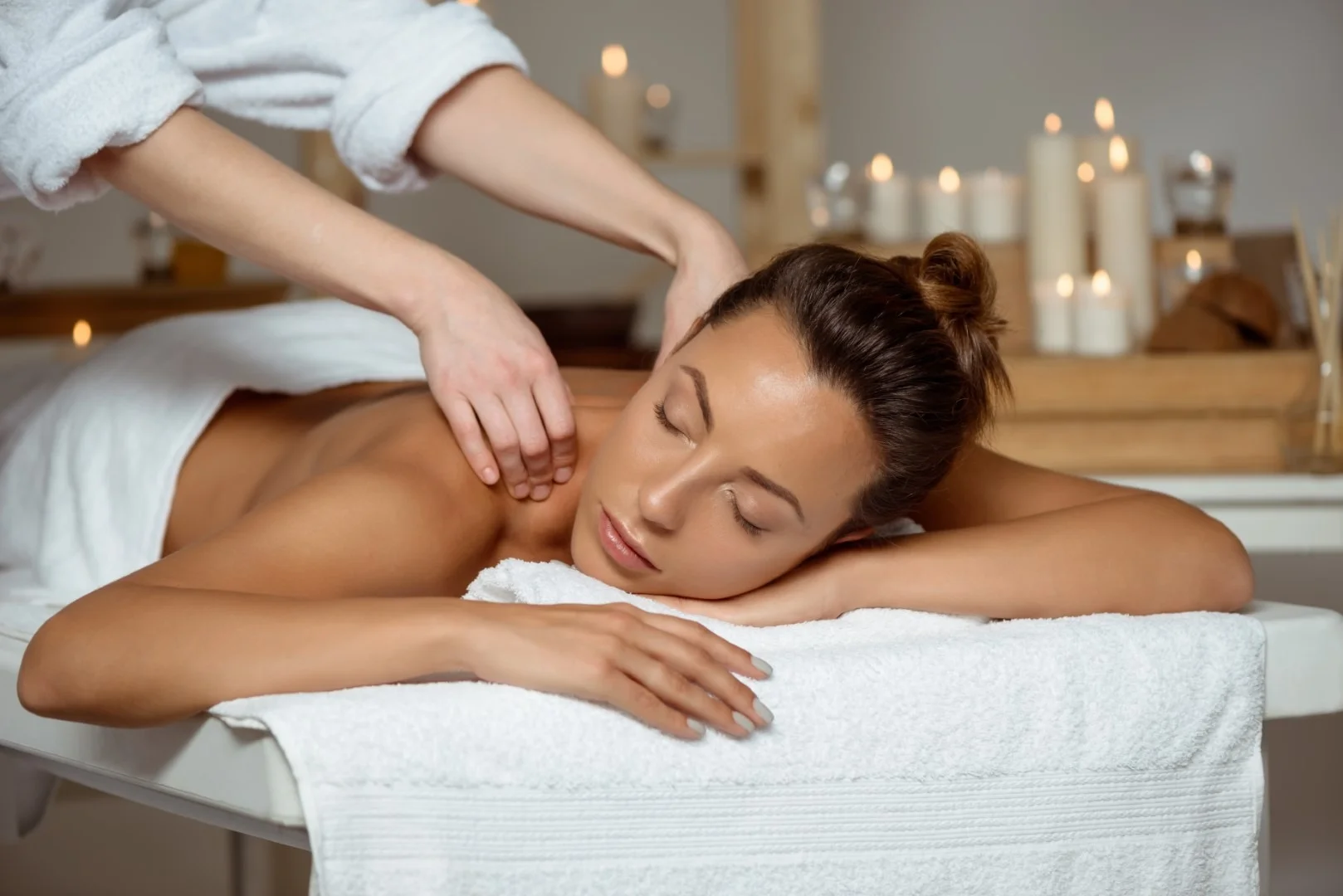 Young attractive girl having massage relaxing in spa salon.
